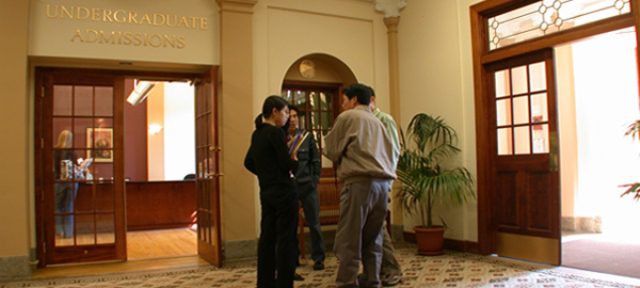 People standing outside of an office with the word “Undergraduate Admissions” written above the door frame.