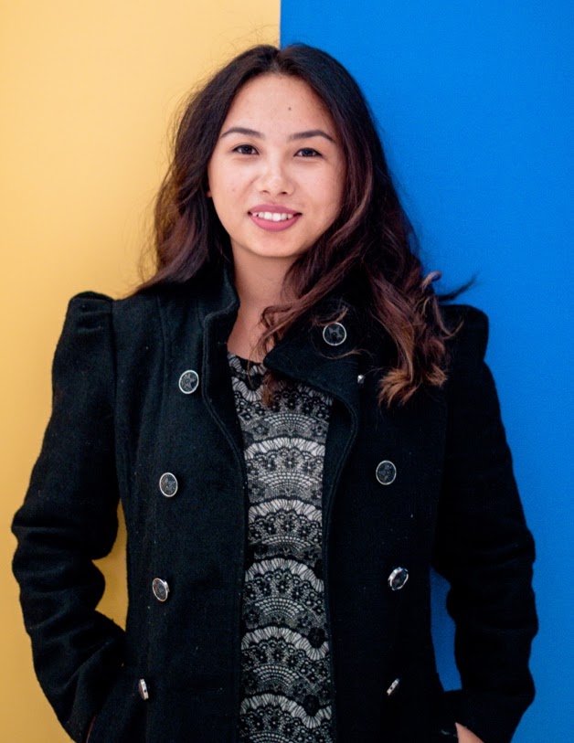 A person standing in front of a yellow and blue background.