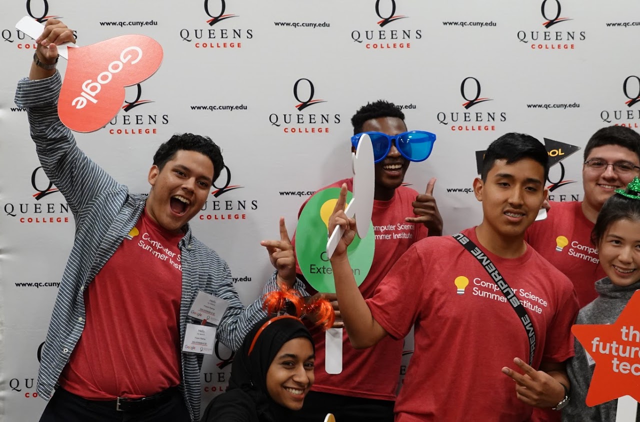 Group photo of participants holding various photobooth prop signs and playfully posing.