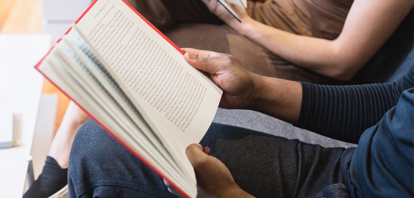Philosophy - Holding an open book. A close-up of a person’s hands holding an open book.