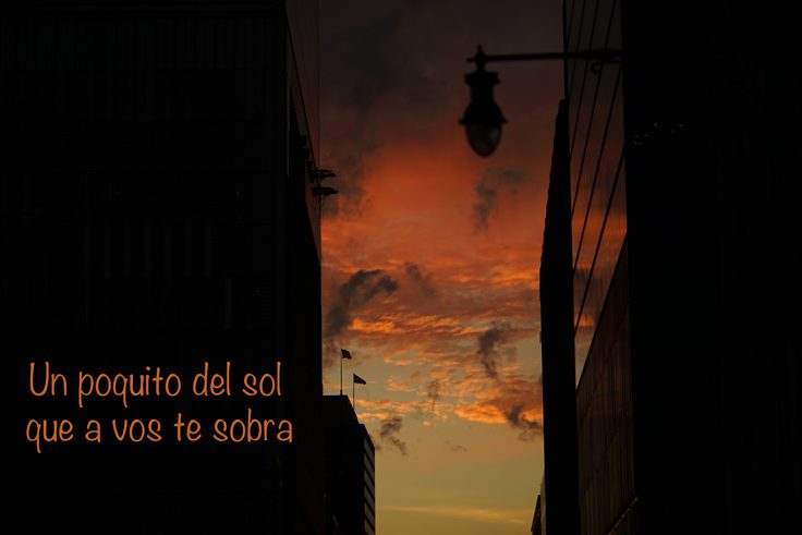 The view of the sky in between buildings. The text reads: Un poquito del sol que a vos te sobra.