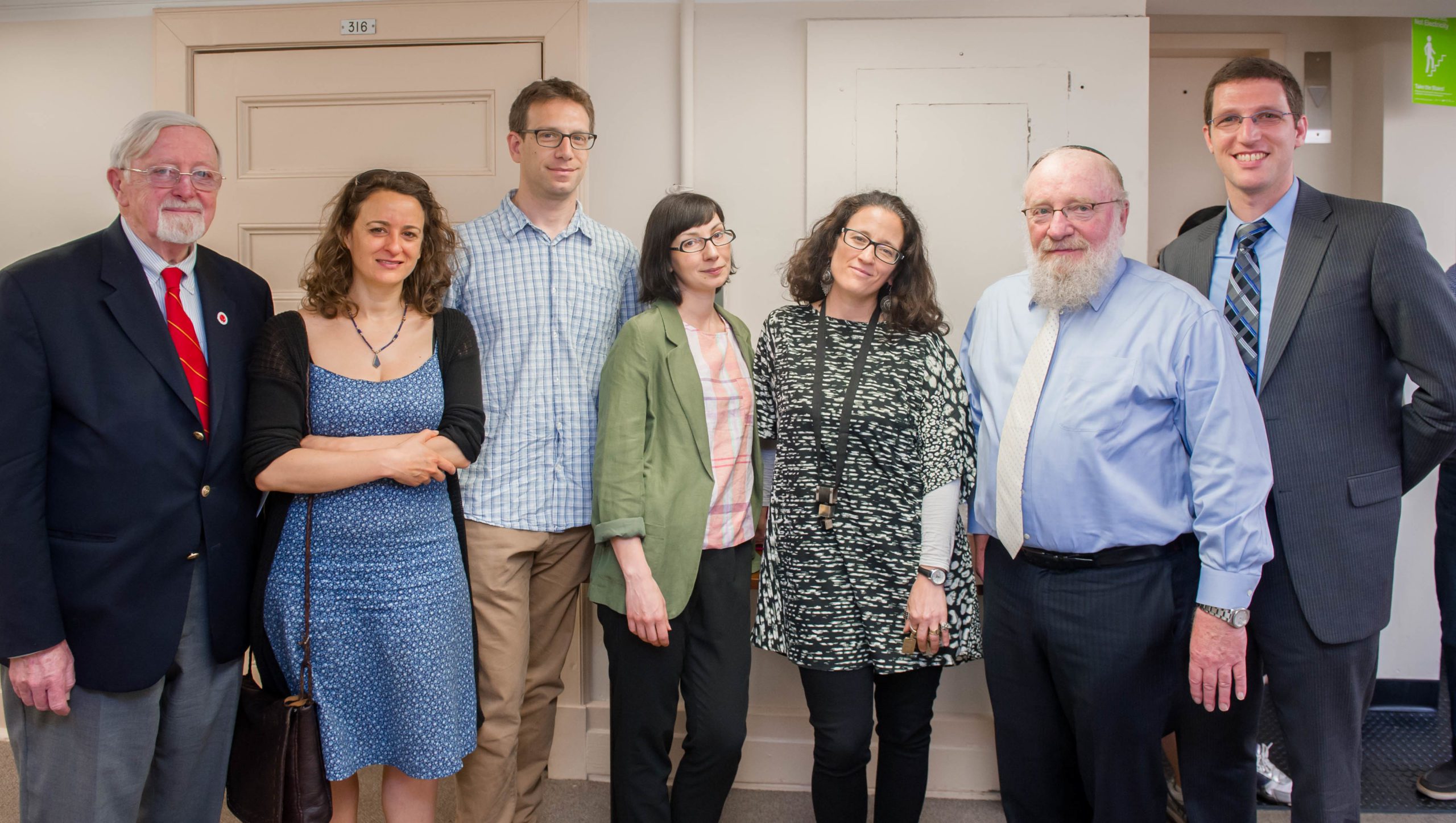 Seven people pose for a group photo.