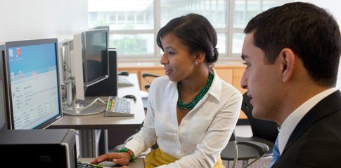 Soribel Genao using a computer while a person observes her.