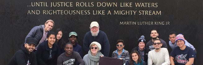 A group photo of the “Footsteps of Dr. King” trip. In the background a quote is written on the wall. It reads “…Until justice rolls down like waters and righteousness like a mighty stream” – Martin Luther King Jr. A group photo of the “Footsteps of Dr. King” trip. In the background a quote is written on the wall. It reads “…Until justice rolls down like waters and righteousness like a mighty stream” – Martin Luther King Jr.