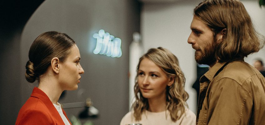 A close-up of three people having a conversation.