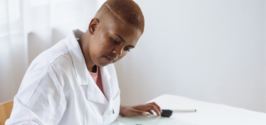 A person in a lab coat presumably writing. (Not in view)
