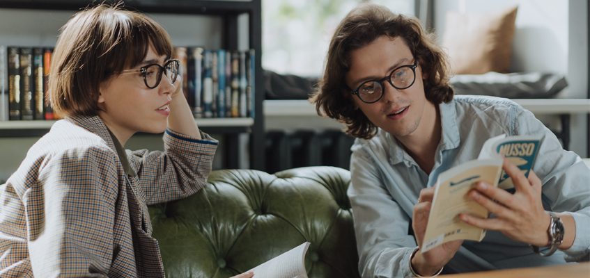 Two people sitting together looking at a book.