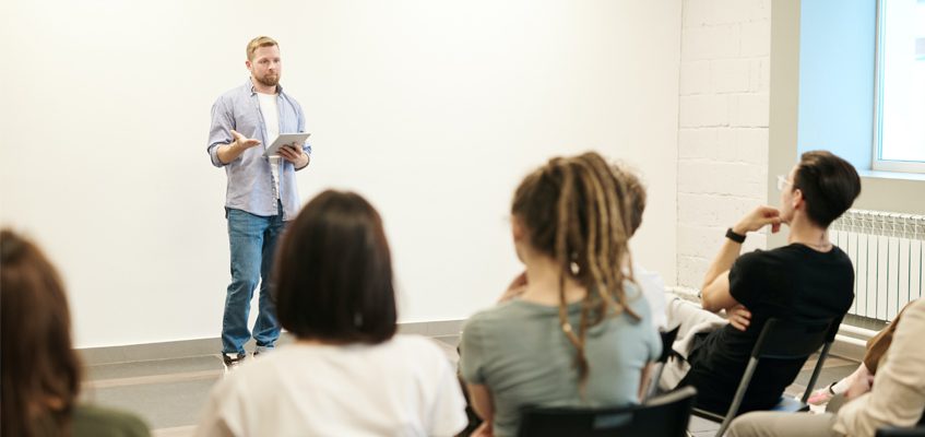 A person giving a lecture in front of a class.