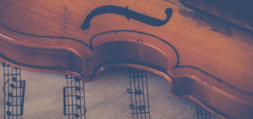 A close-up of a violin resting on sheet music.