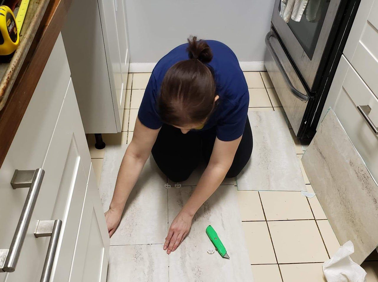 Corinna Singleman completing home improvements on her tiled kitchen floor. 