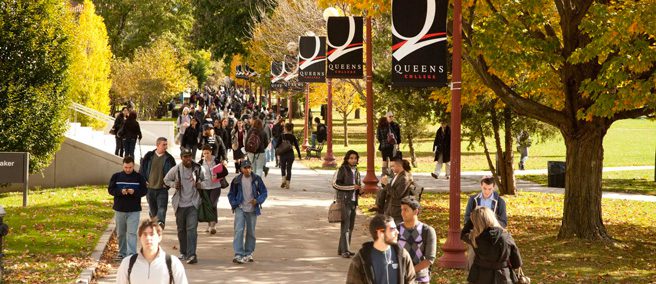 Students walking through the entrance gate at Queens College. 