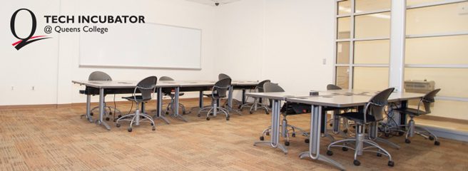 Tech Incubator at Queens College-Two large tables with computer chairs in a Tech Incubator room Two large tables with computer chairs in a Tech Incubator room