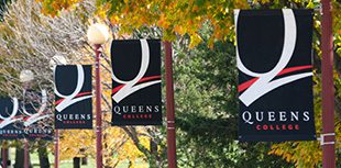 The Queens College Logo Banners on light poles outdoors.