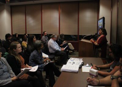 A lecturer standing behind a podium while speaking to the audience.