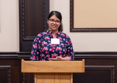 Nabila speaking at a podium.