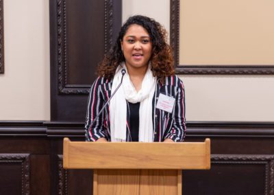 Sarah speaking at a podium.