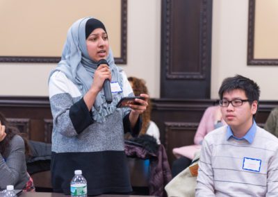 Jabeen Cheema, Student Council Speaker holds a microphone while speaking to the audience.