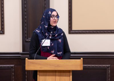 Fawzia speaking at a podium.