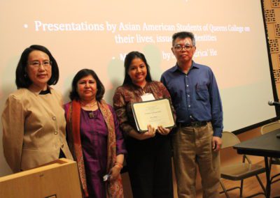 Rita Malo, Sophomore, Political Science and Comparative Literature Major holds up scholarship with three people beside her.