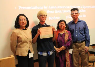 Franklin Paek, Freshman, Major Undecided holds up scholarship with three people beside him.