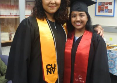 Two graduates posing for a group photo.