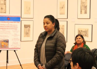 Student Participant standing next to a poster and speaking.