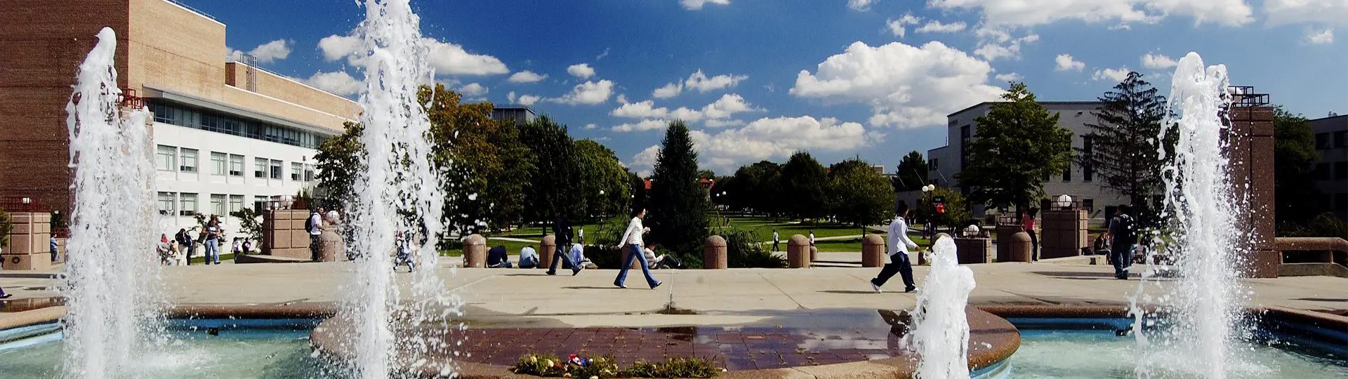 People walking by the fountain beside Benjamin Rosenthal Library.