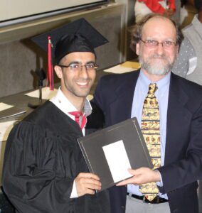 Two people holding a diploma.