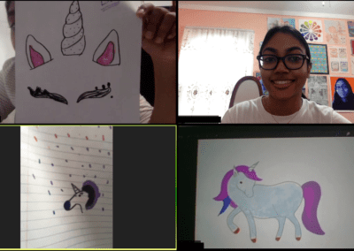 A screenshot of a video call with four participants. Three of the four participants are holding up a drawing of a unicorn.