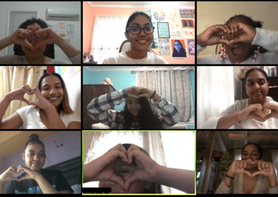 A screenshot of a Group Video Call participants creating the heart symbol with their hands.