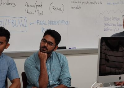 A close-up of the presenters sitting in front of the classroom.