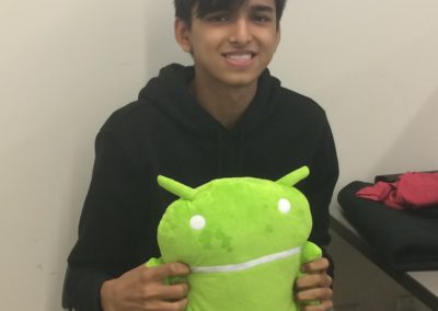 A student holding the Android stuffed animal mascot.