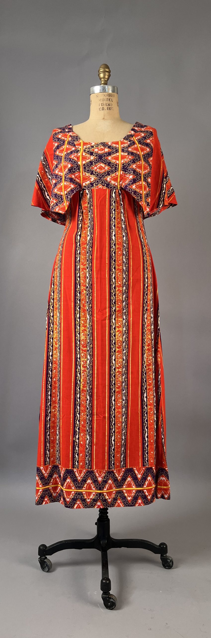 2 TEENA TANZANIA Multicolored kanga of orange, yellow, dark blue.