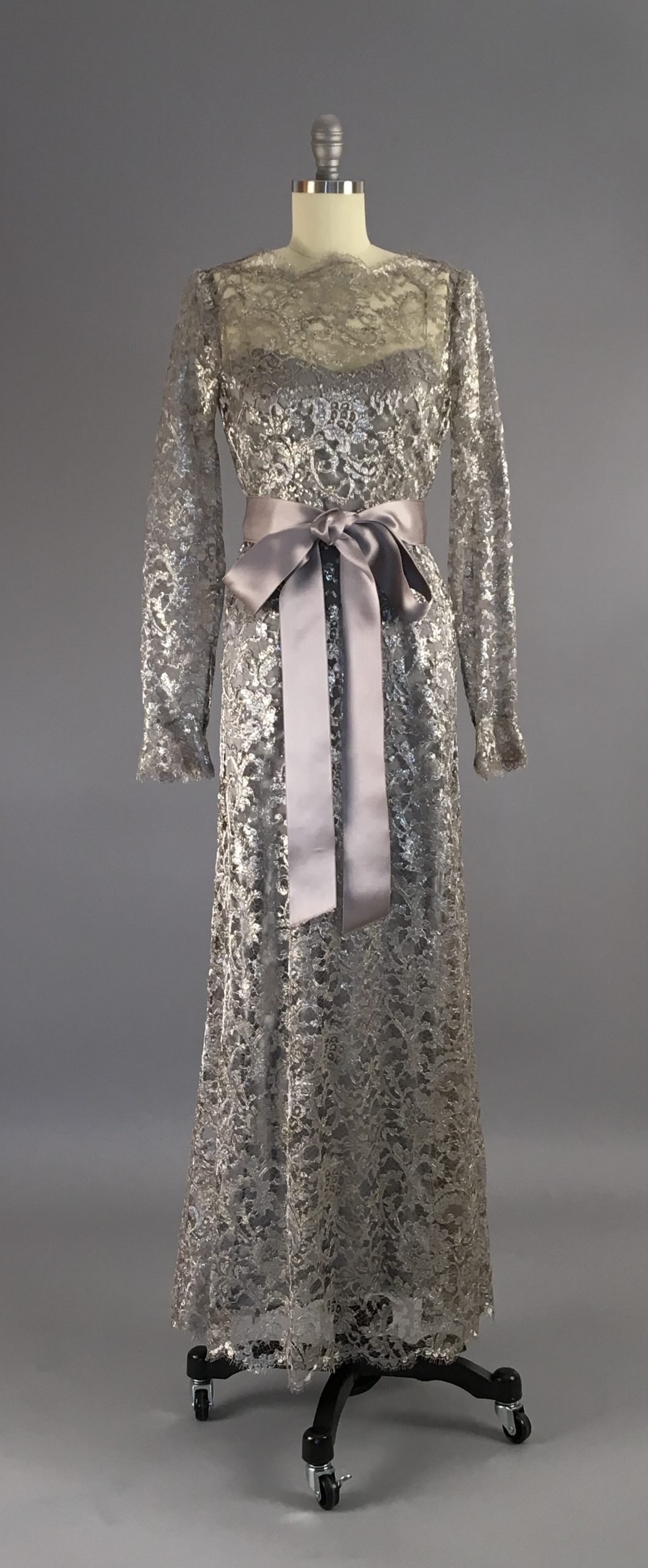 7 YSL SILVER A silver lace dress with a matching lace belt, tied into a bow.