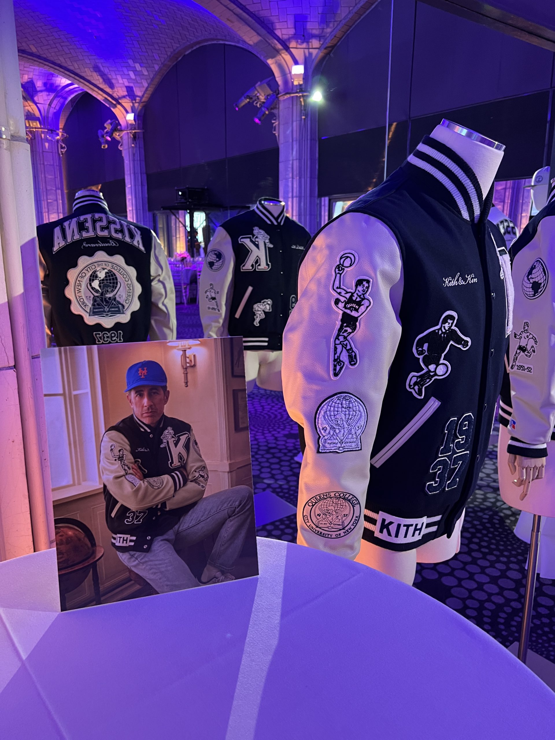 8 KITH 5 A blue and white varsity jacket from Kith next to a photo of Jerry Seinfeld wearing the same jacket.
