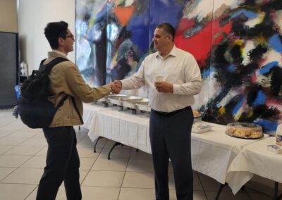 QC Alumnus Lee A. Korn shakes hand with student