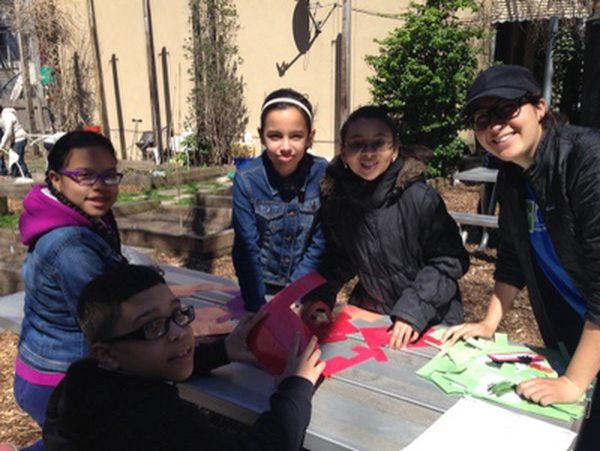 A group of students sitting at an outdoor picnic table.