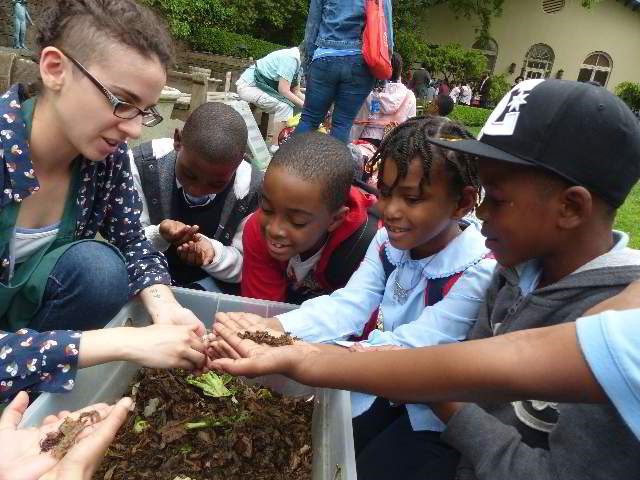 A group of children observing soil sample.