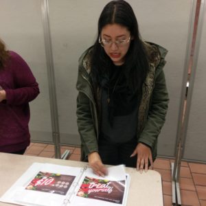 A person looking at an open book. A person looking at an open book on a table.