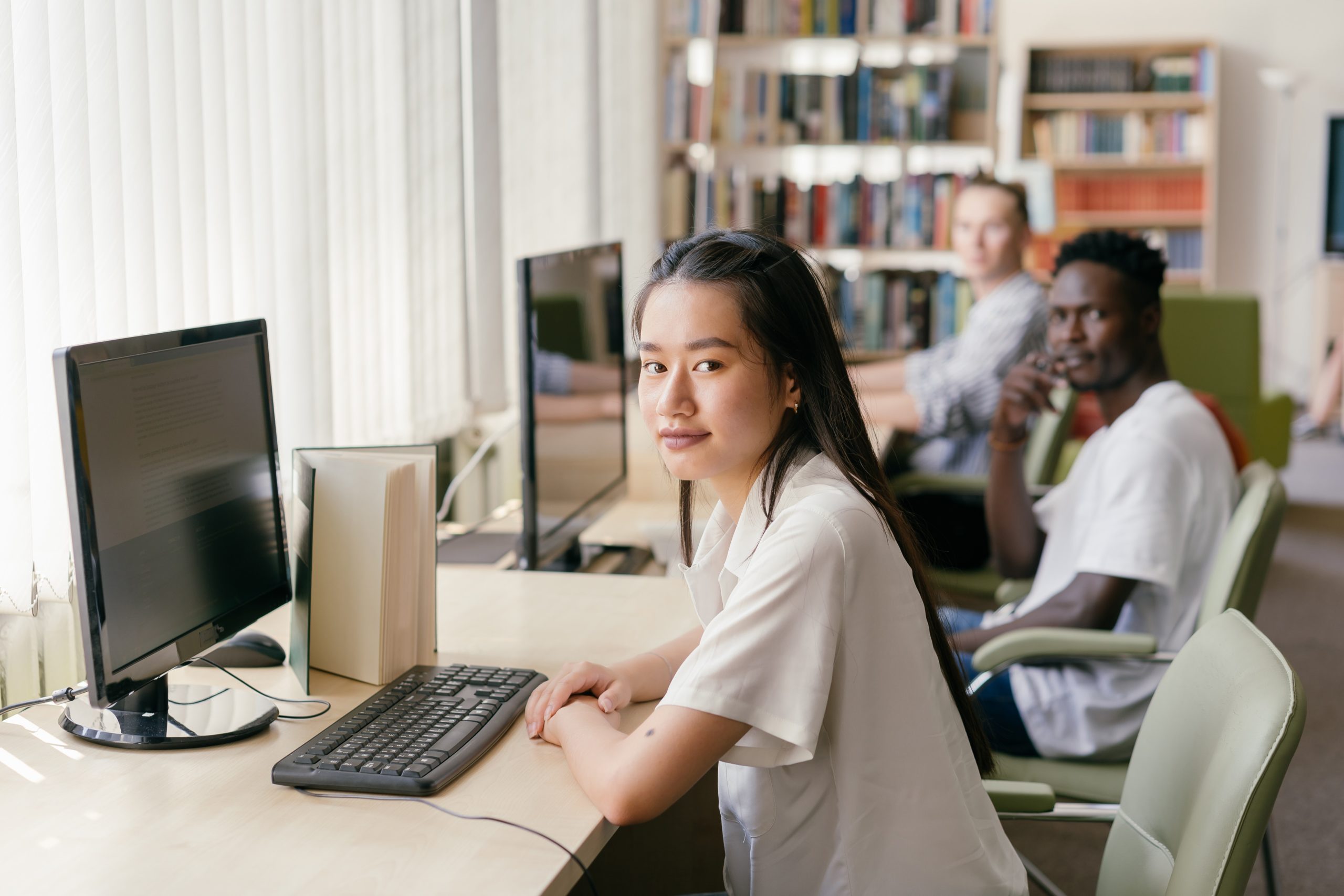 Three people sitting in front of their computers