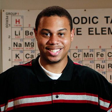 Freshman_2_2012_CS_PA_14377 African American man smiling with periodic table in background