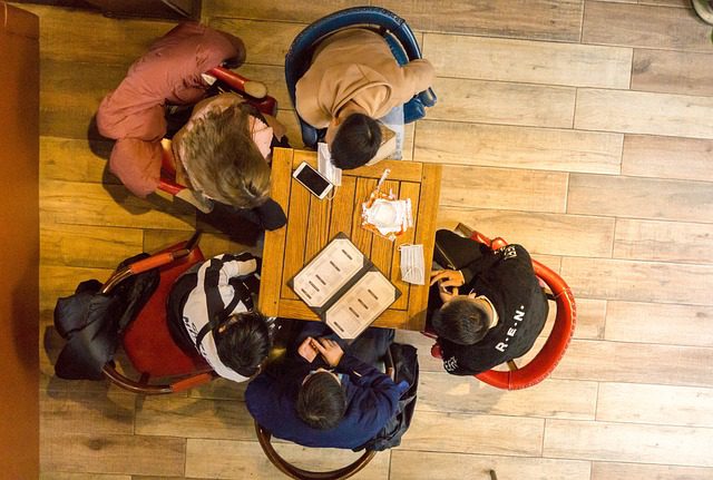 Students gathered around table, chatting and eating