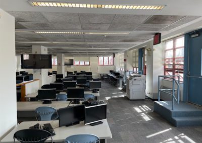 IB-200 computer lab with desks, computers, and printer before renovations.