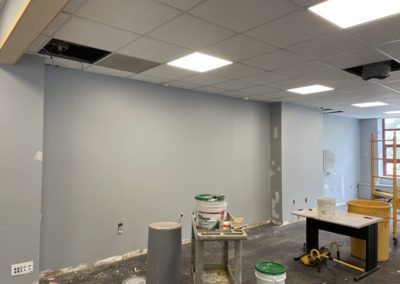 Unfinished wall and ceiling renovations with equipment and paint buckets.