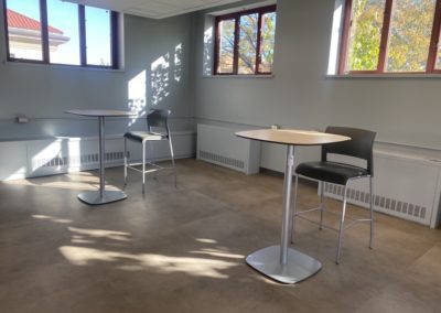 Chairs with tables located by windows.