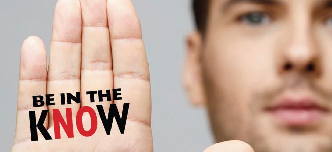 A man holds up his hand, palm facing the camera with his fingers held together. “Be in the Know” is written on his hand.