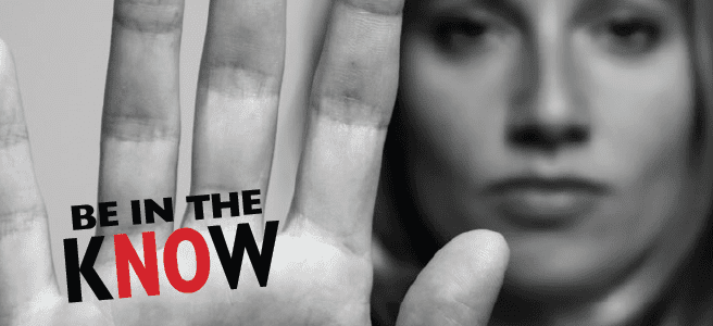 A woman holds up her hand, palm facing the camera with fingers slightly outstretched. “Be in the Know” is written on her hand.