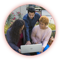 Three people looking at a laptop.