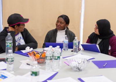 Three people having a conversation at a table.