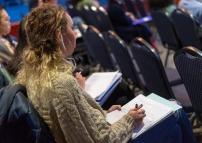 People sitting in rows taking notes.